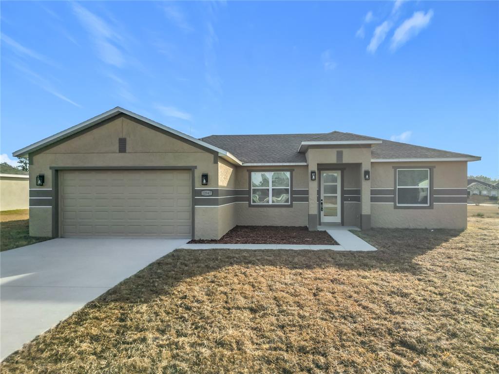 A modern kitchen features white cabinets, stainless steel appliances, and a gray-toned tile backsplash — 12847 SW 73RD TERRACE, OCALA, FL