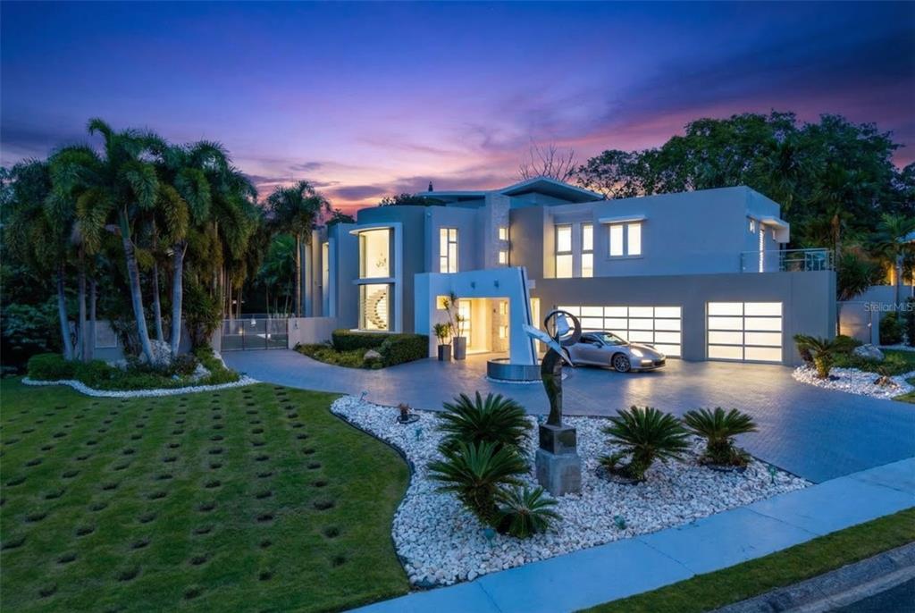 A modern two-story house features a swimming pool, covered outdoor kitchen, and landscaped backyard — 57 QUINTAS DE SANTA MARIA II, MAYAGUEZ, PR