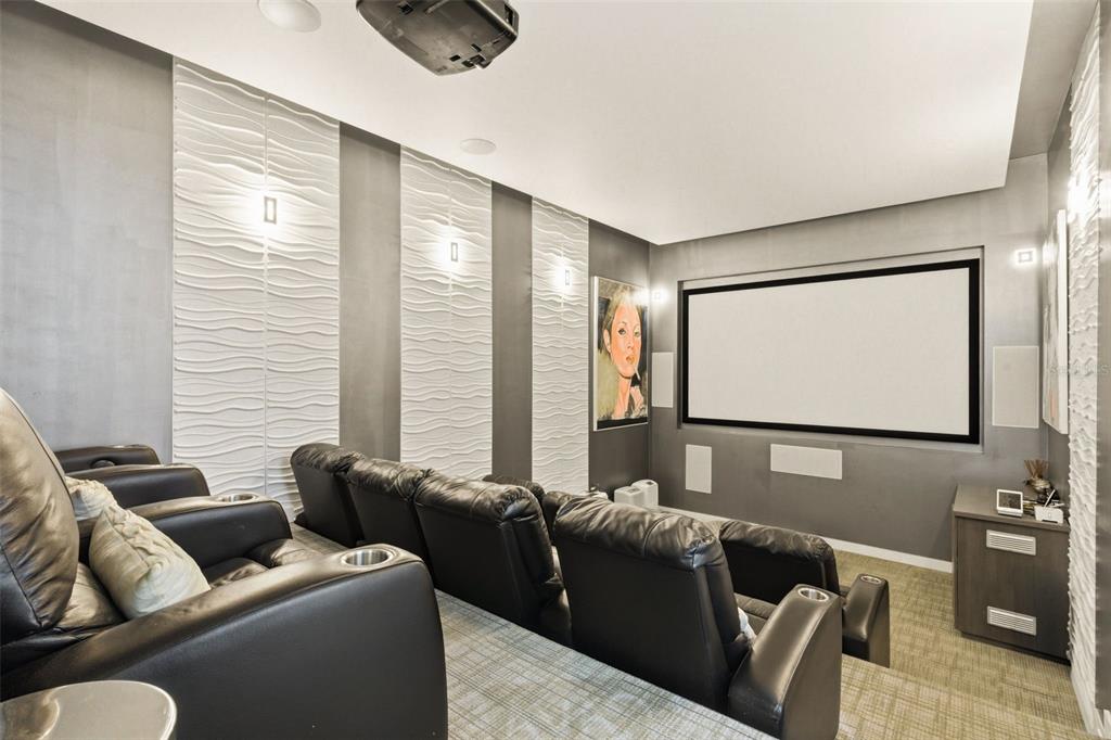 A home theater features tiered leather seating, a projector, and textured white wall panels — 57 QUINTAS DE SANTA MARIA II, MAYAGUEZ, PR