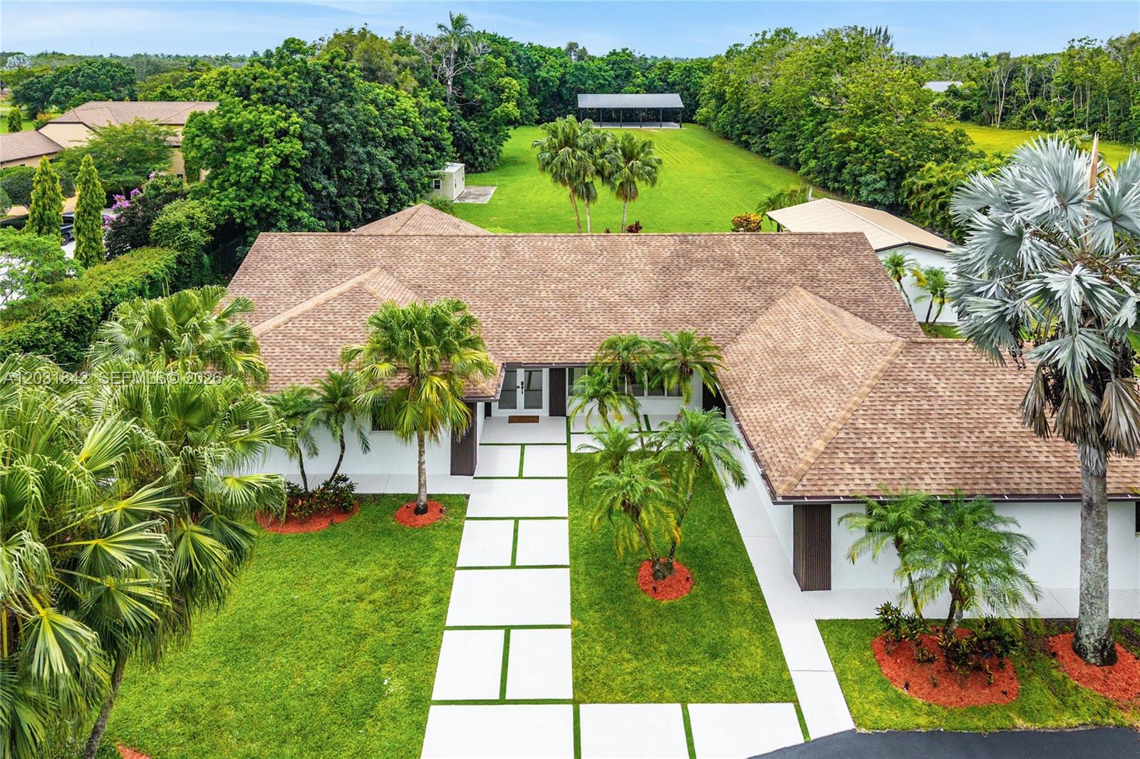 A single-story house with a circular driveway and palm trees at dusk — 13900 Mustang Trl, Southwest Ranches FL 33330, SOUTHWEST RANCHES, FL