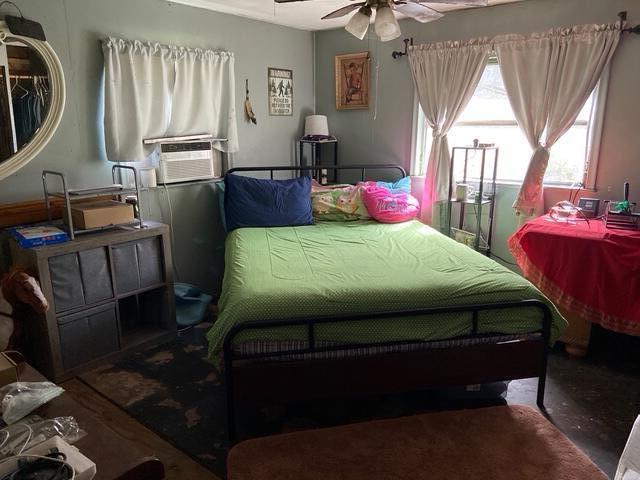 A bedroom features a metal-framed bed with green bedding, a window with curtains, and storage — 15137 NE 141st Street, FL 32134, FL