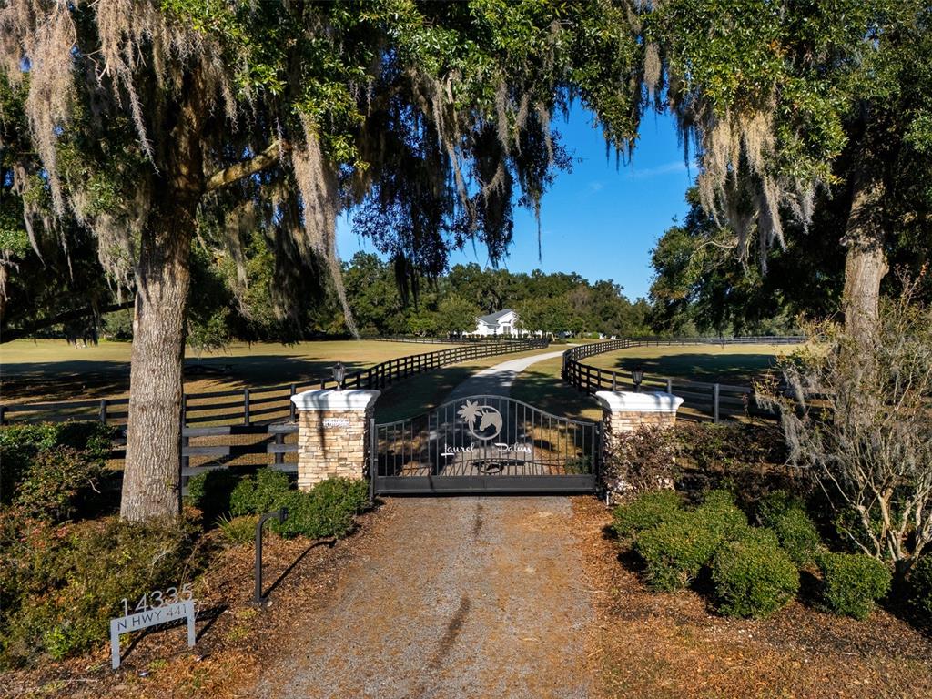 An aerial view shows a gated entrance with a long driveway leading to a house — 14335 N US HIGHWAY 441, CITRA, FL