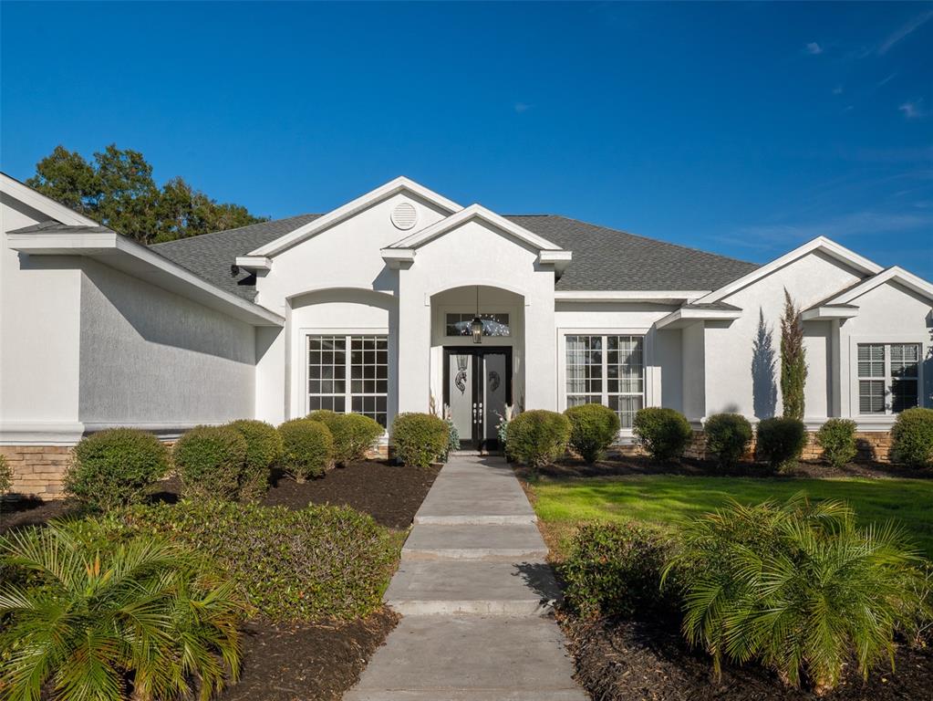 A white stucco house with a gray shingled roof and a concrete walkway — 14335 N US HIGHWAY 441, CITRA, FL
