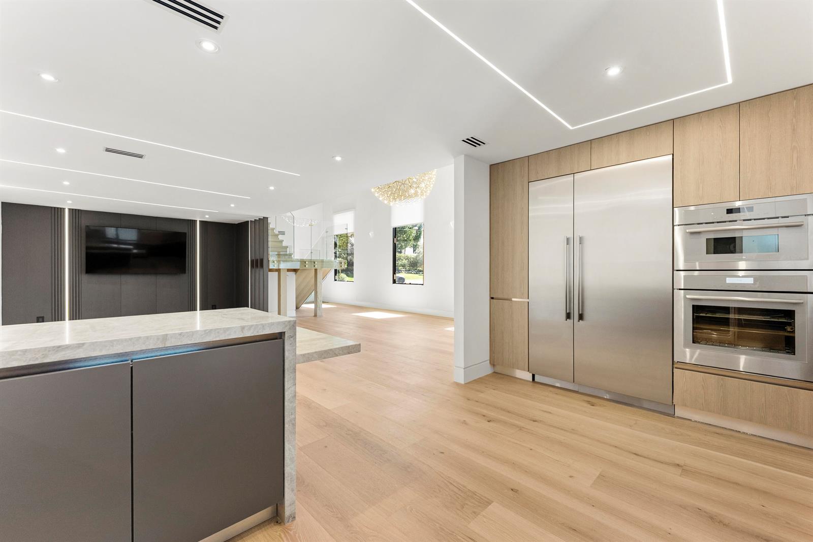 A modern kitchen features light wood cabinetry, stainless steel appliances, and a marble-topped island — 1692 S Ocean Boulevard, Delray Beach FL 33483, DELRAY BEACH, FL