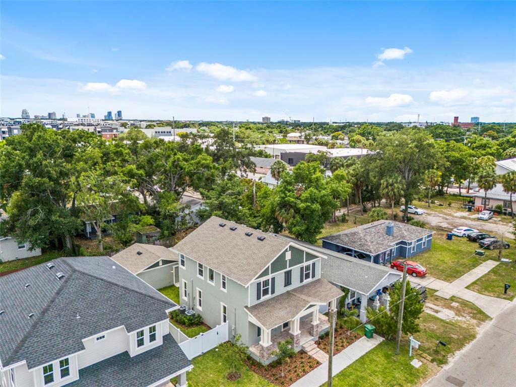 An aerial view shows a light green two-story house surrounded by trees and neighboring homes — 1526 W ARCH STREET, TAMPA, FL