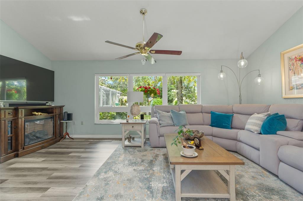 A living room features a large sectional sofa, a fireplace console, and a ceiling fan — 4 IPOMOEA COURT, HOMOSASSA, FL