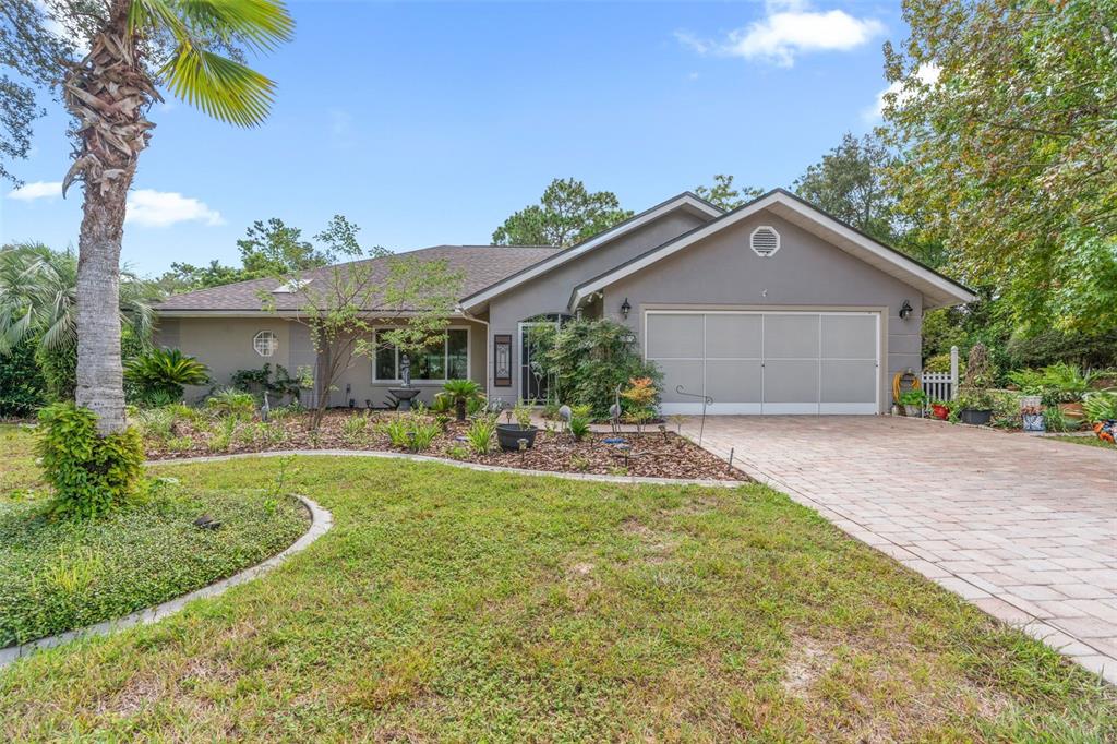 A single-story house with a gray exterior, a paved driveway, and a landscaped front yard — 4 IPOMOEA COURT, HOMOSASSA, FL