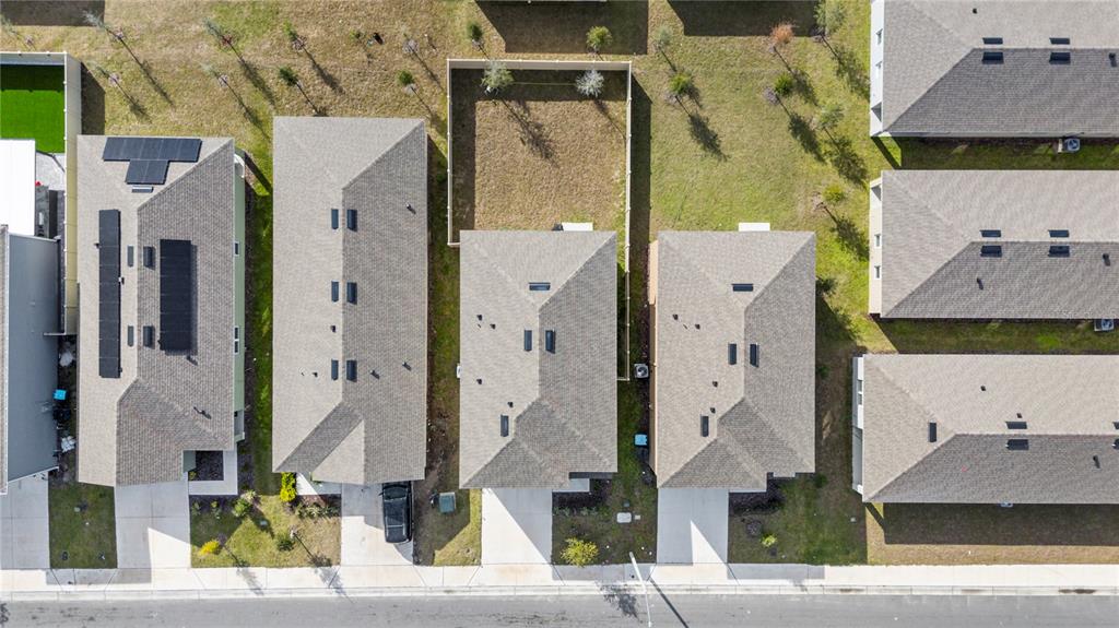 An aerial view shows several suburban houses with gray roofs and driveways along a street — 2630 ANGEL FALLS DRIVE, DAVENPORT, FL