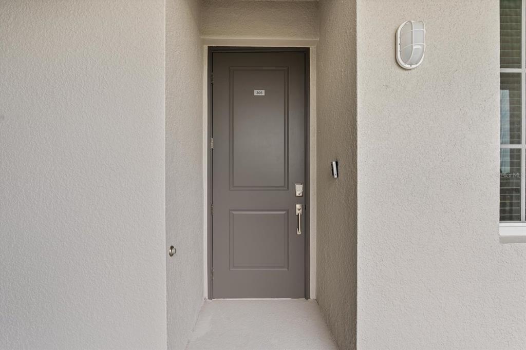 A gray front door with the number 305 is set within a recessed entryway — 12180 WELLEN GOLF STREET UNIT 305, VENICE, FL