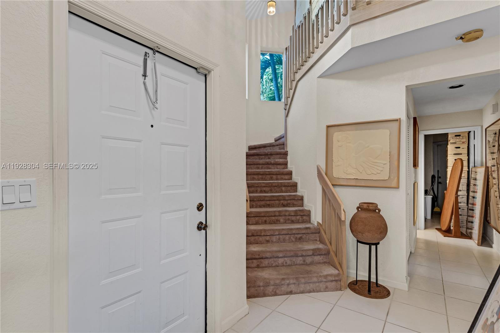 An entryway features a white door, carpeted stairs, and a large decorative clay pot — 10132 NW 4th St, Plantation FL 33324, PLANTATION, FL