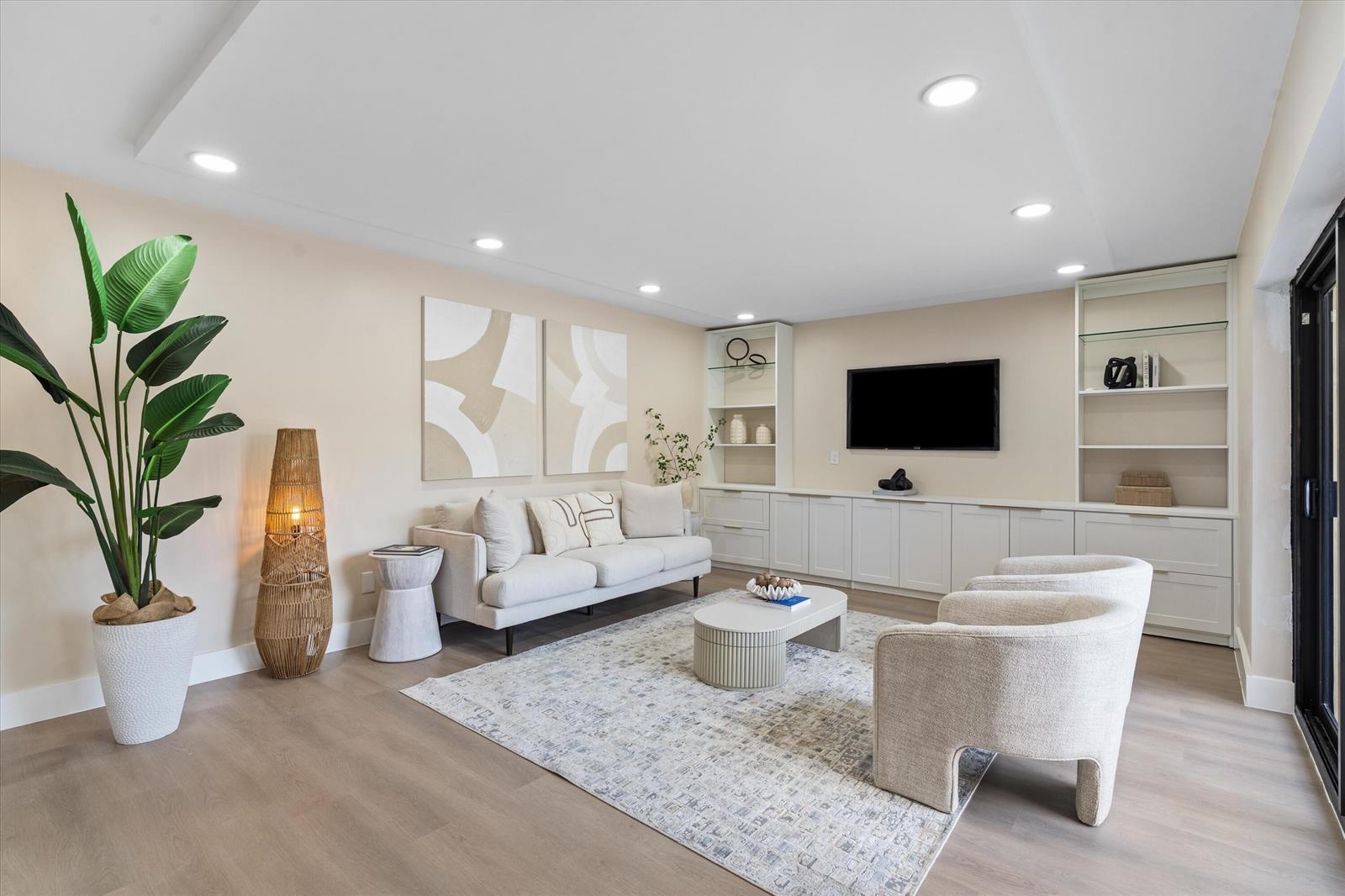 A living room features a sofa, two armchairs, a coffee table, and built-in shelving — 825 Center Street # 49d, Jupiter FL 33458, JUPITER, FL
