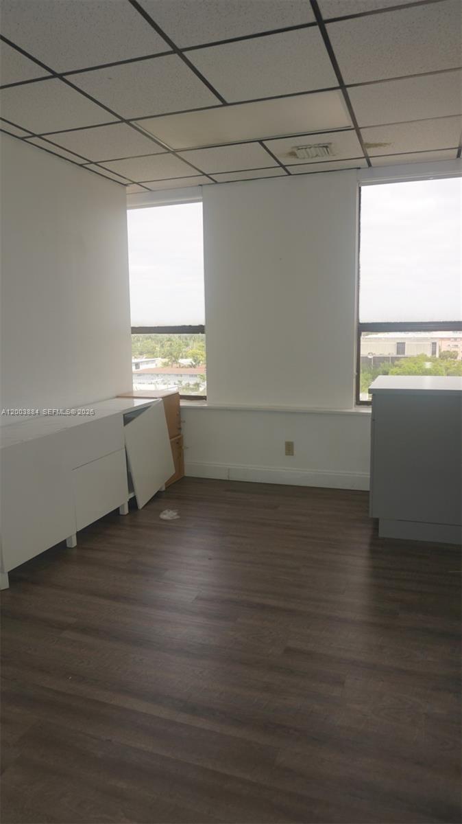 An office room features wood-look flooring, a drop ceiling, and two windows with views — 1250 E Hallandale Beach Blvd, Hallandale Beach FL 33009, HALLANDALE BEACH, FL