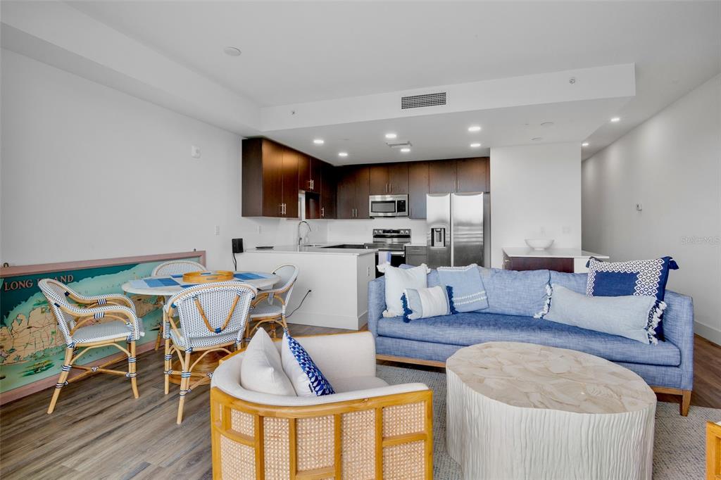 An open-concept living and dining area features a kitchen with dark cabinets and stainless appliances — 1709 N TAMIAMI TRAIL UNIT 416, SARASOTA, FL