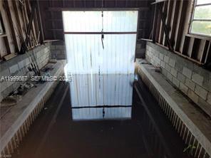 A flooded garage with exposed concrete block walls and wooden framing — 1104 Gulf St, Moore Haven FL 33471, MOORE HAVEN, FL