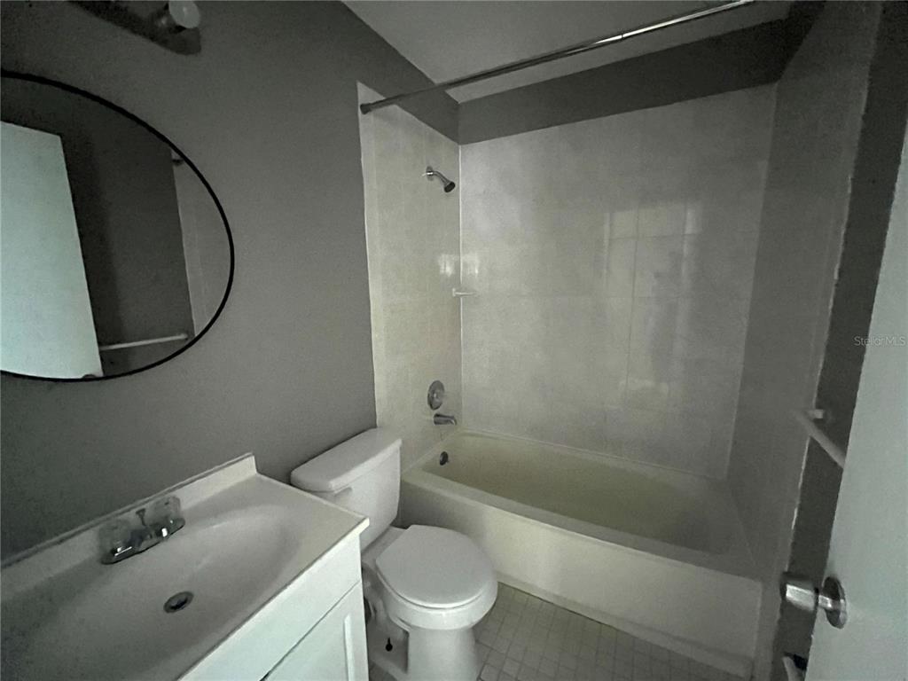 A bathroom features a white vanity, a toilet, and a shower-tub combination with tiled walls — 2603 SW 152ND LANE, OCALA, FL