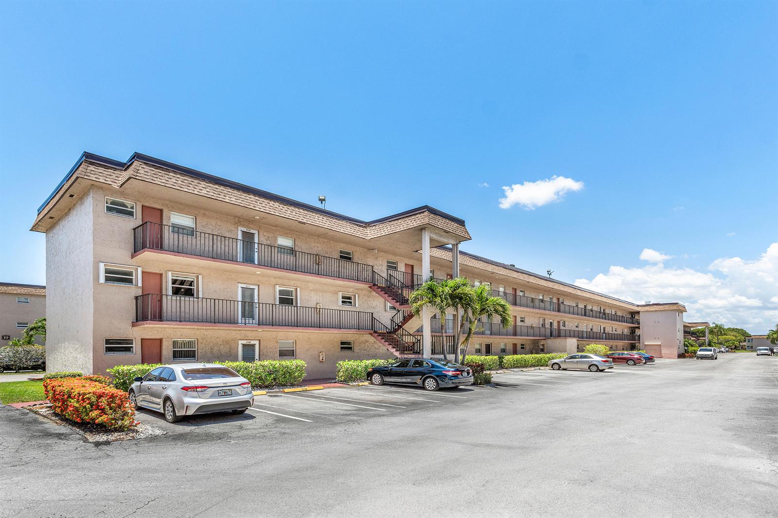 A three-story apartment building with exterior walkways and a parking lot in front — 721 Lori Drive # 208, Palm Springs FL 33461, PALM SPRINGS, FL