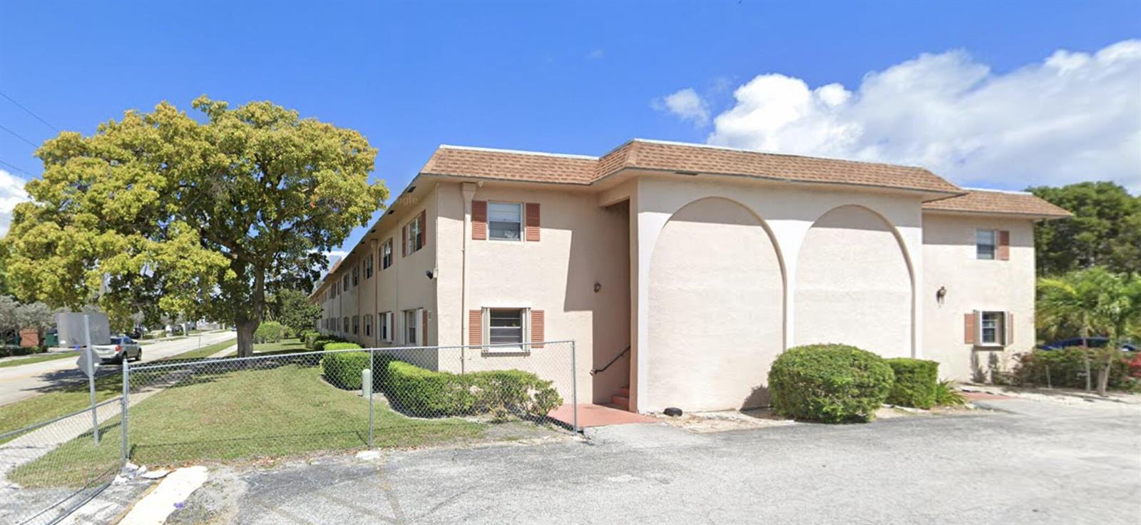 A two-story apartment building with tan stucco walls and arched architectural details on the exterior — 650 SW 2nd SW # 2480, Boca Raton FL 33432, BOCA RATON, FL