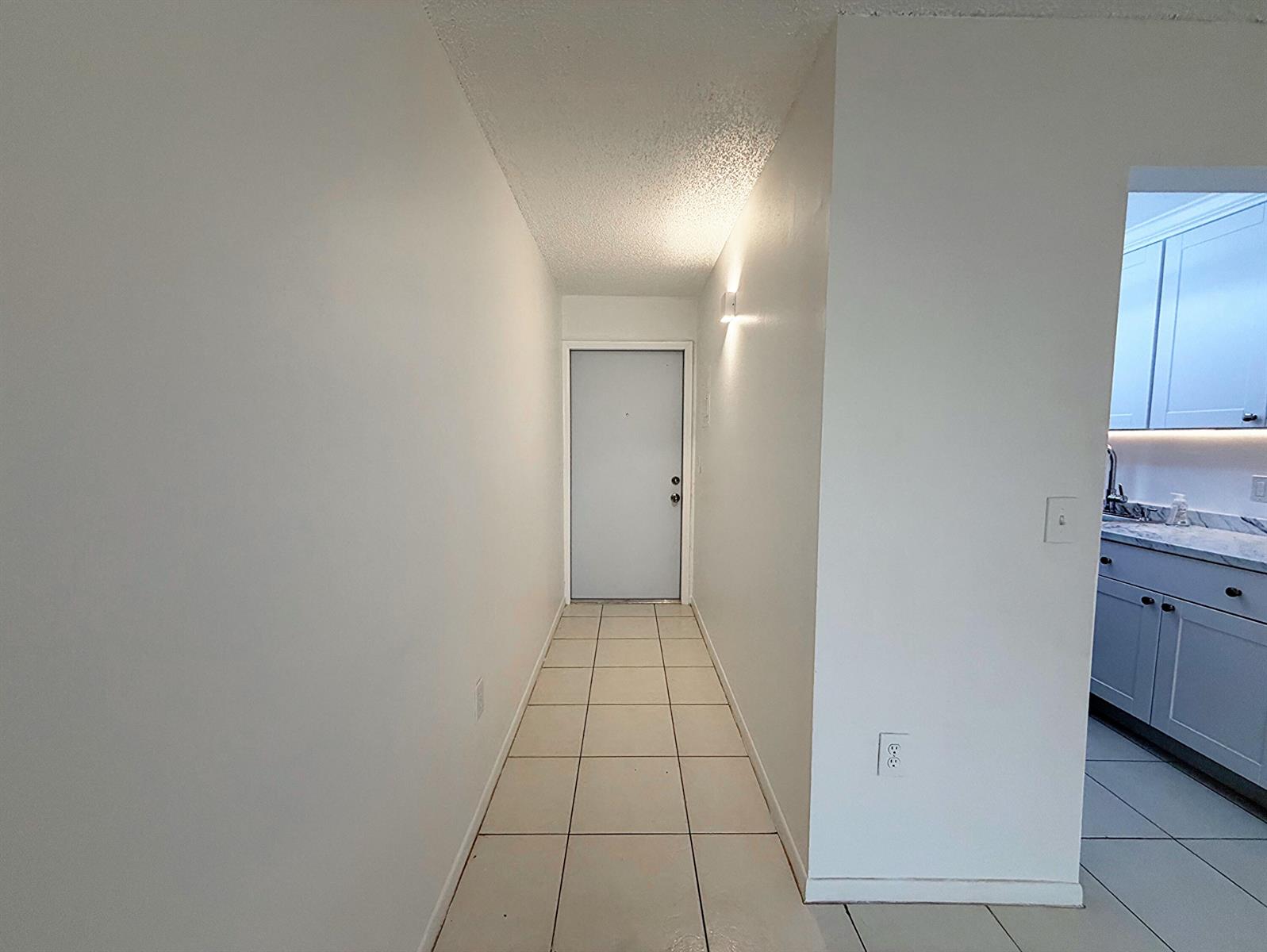 A tiled hallway leads to a front door, with a kitchen visible to the right — 650 SW 2nd SW # 2480, Boca Raton FL 33432, BOCA RATON, FL