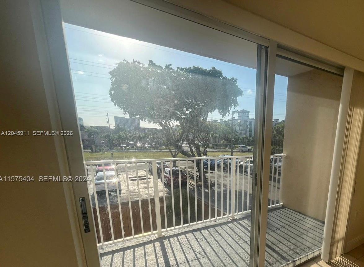 A view from inside a room through a sliding glass door onto a balcony — 5112 NW 79 Ave # 202, Doral FL 33166, DORAL, FL