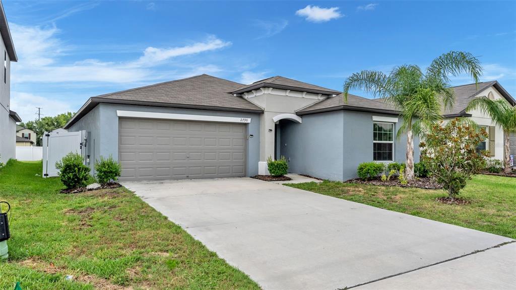 A single-story house with a gray exterior, a two-car garage, and a front lawn — 2790 RED EGRET DRIVE, BARTOW, FL