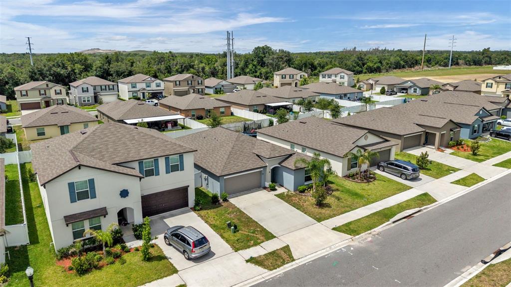 An aerial view shows a suburban street with several single-family homes and driveways — 2790 RED EGRET DRIVE, BARTOW, FL