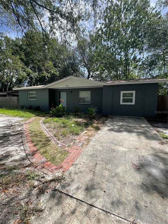 A single-story house with dark gray siding, a brick walkway, and a concrete driveway — 3803 NE 13TH STREET, GAINESVILLE, FL