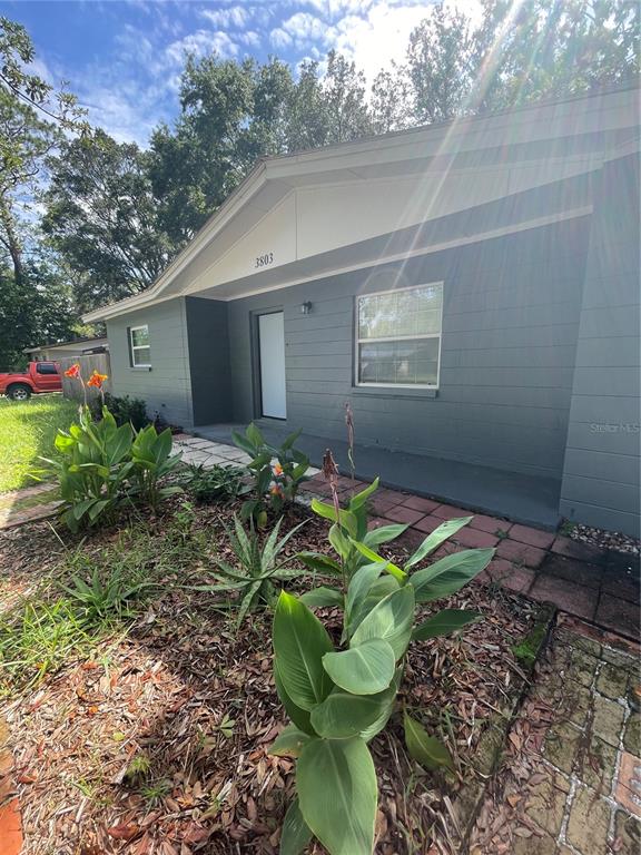 A gray, single-story house with a white door and a brick walkway in front — 3803 NE 13TH STREET, GAINESVILLE, FL