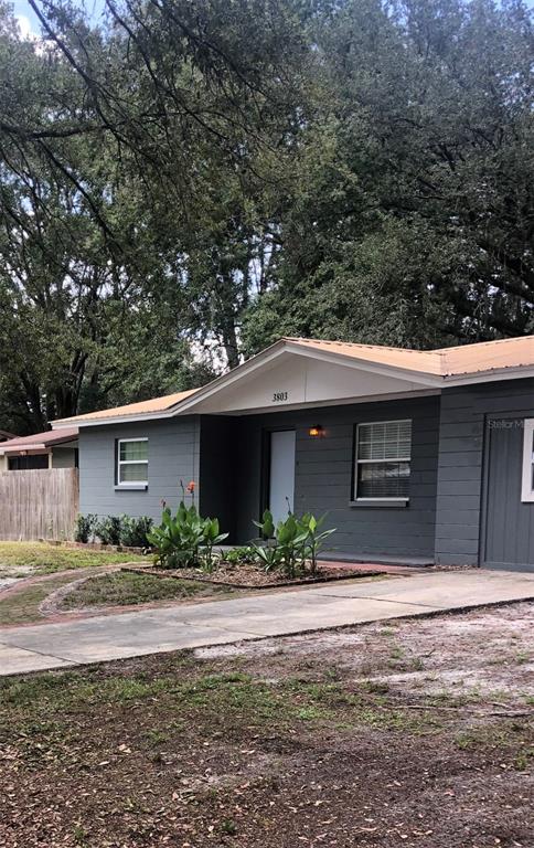 A single-story gray house with a metal roof and a concrete driveway — 3803 NE 13TH STREET, GAINESVILLE, FL