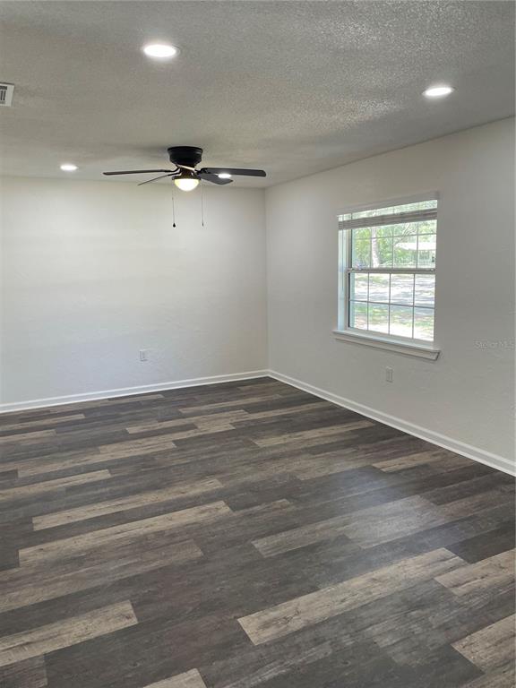 A room with light-colored walls, recessed lighting, a ceiling fan, and dark wood-look flooring — 3803 NE 13TH STREET, GAINESVILLE, FL