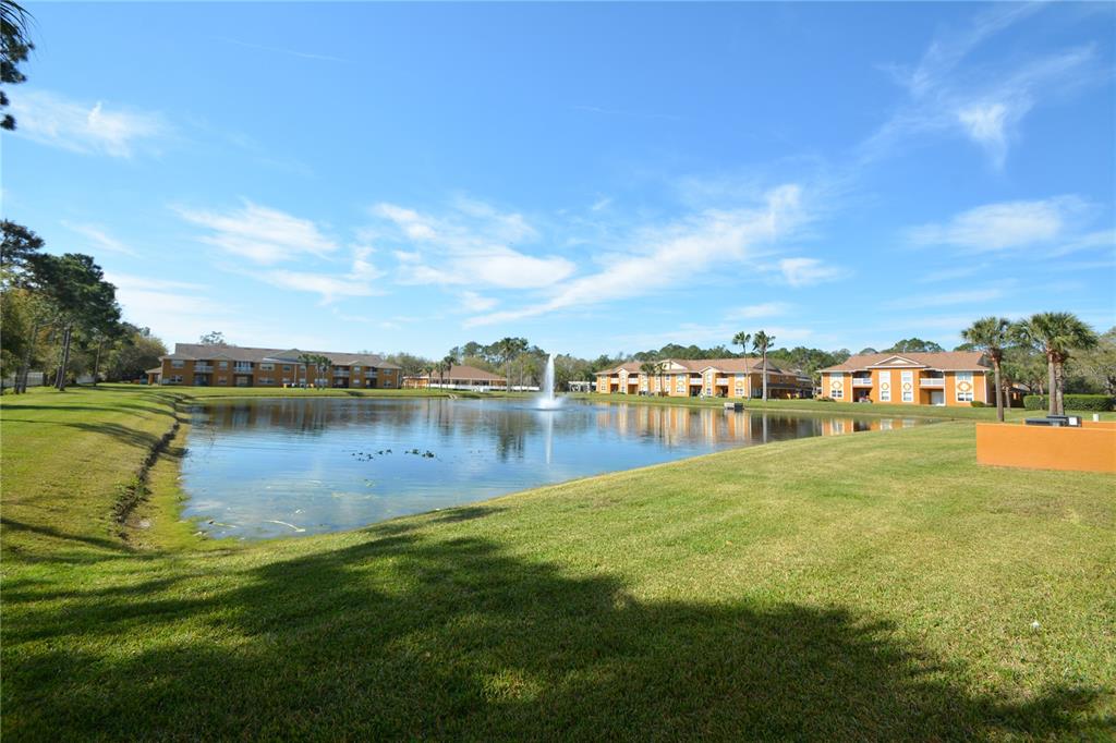 A pond with a fountain sits in front of multi-story apartment buildings and green lawns — 4600 E MOODY BOULEVARD UNIT 4H, BUNNELL, FL