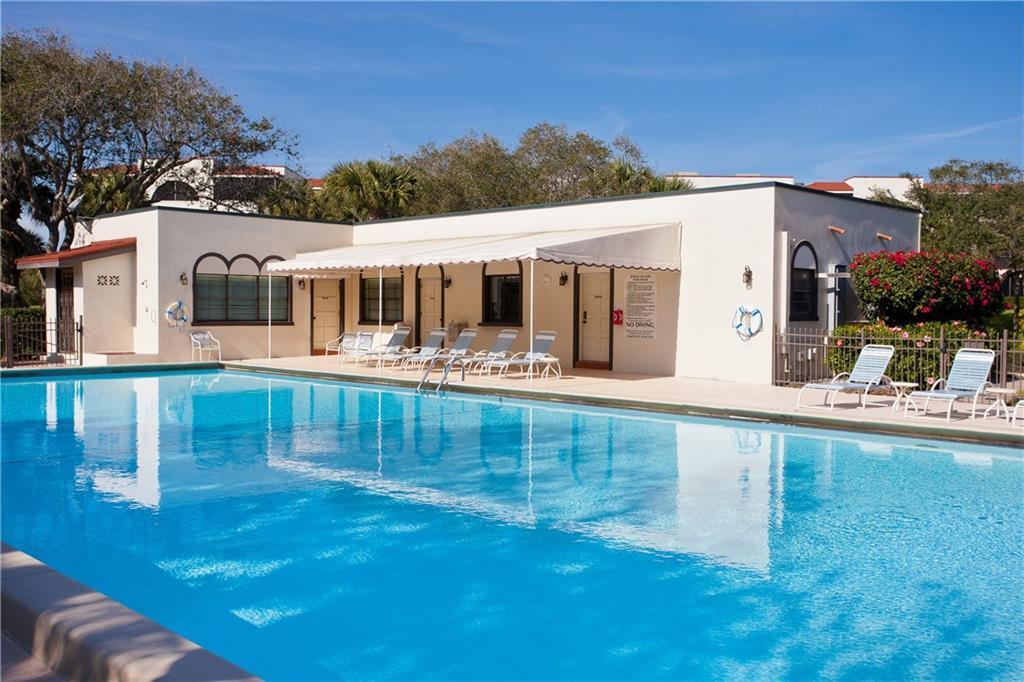 A swimming pool sits in front of a single-story building with a covered patio area — 5601 Highway A1a # 304n, Vero Beach FL 32963, VERO BEACH, FL