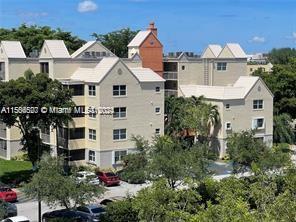 An exterior view of a multi-story residential building with light-colored siding and a gabled roof — 8255 Lake Dr # 204, Doral FL 33166, DORAL, FL