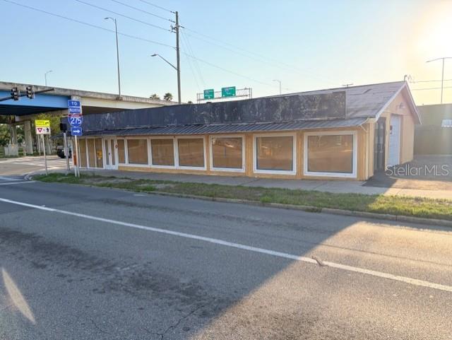 A single-story commercial building with boarded-up windows sits beside an overpass — 1601 5TH AVENUE N, ST PETERSBURG, FL