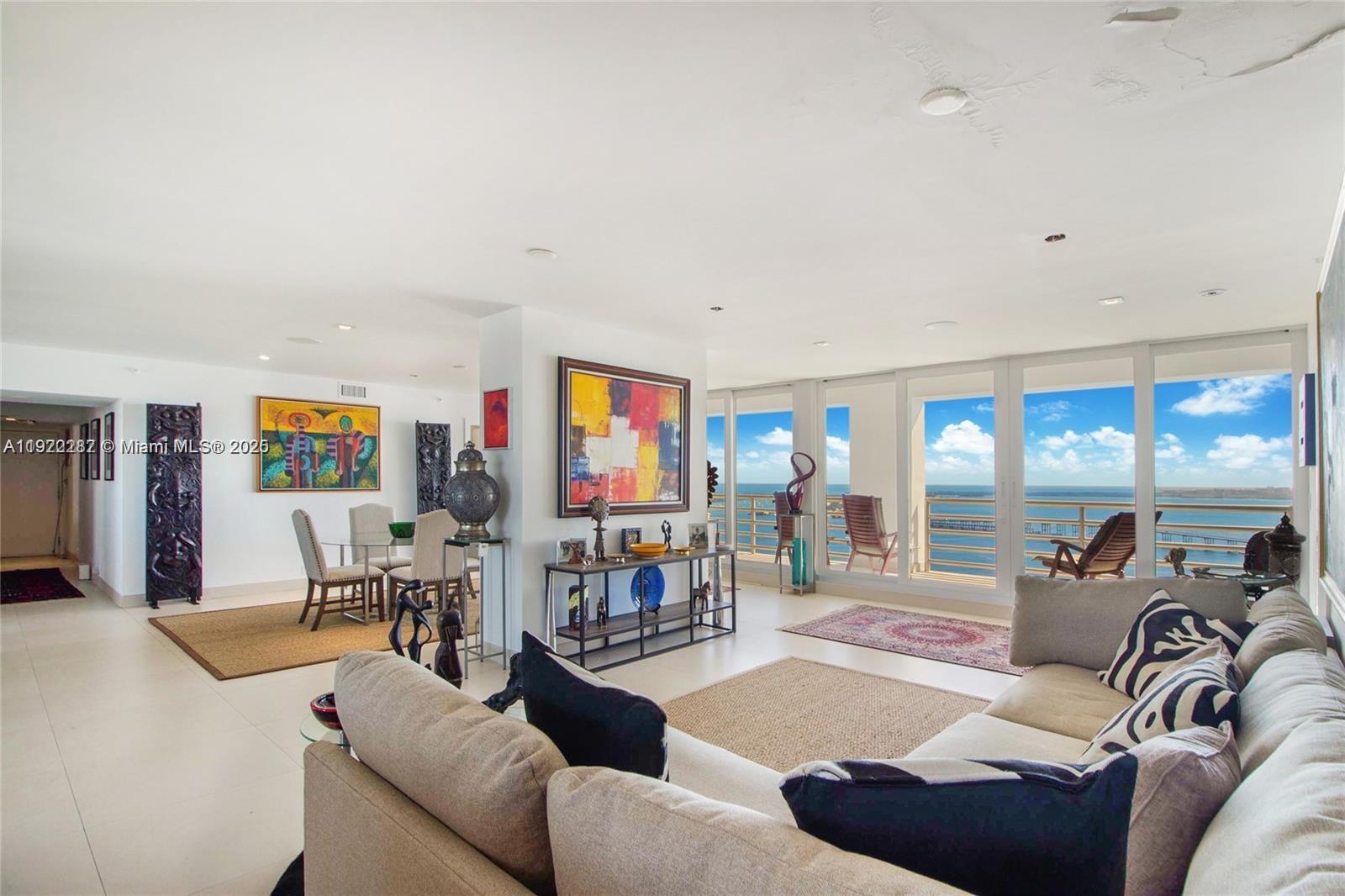 A spacious living and dining area features white tile floors, modern furniture, and floor-to-ceiling windows — 1541 Brickell Ave # 3902, Miami FL 33129, MIAMI, FL