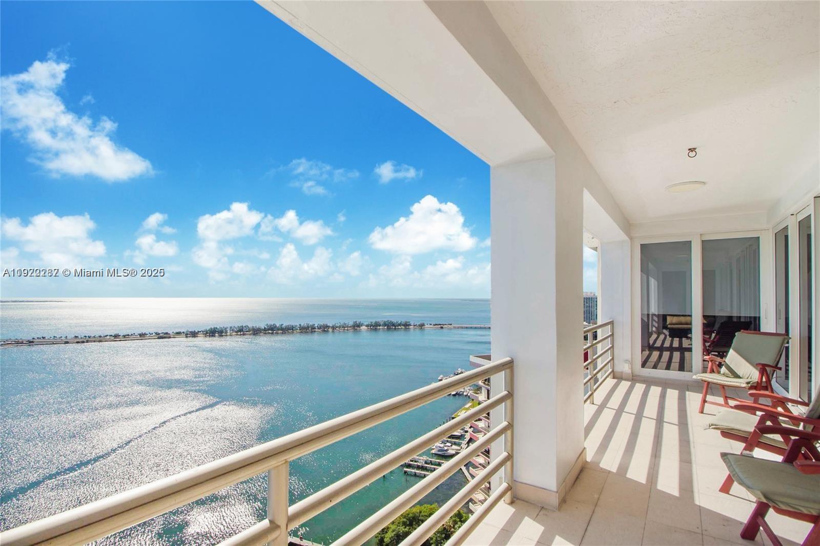 A balcony with a metal railing overlooks a large body of water and sky — 1541 Brickell Ave # 3902, Miami FL 33129, MIAMI, FL
