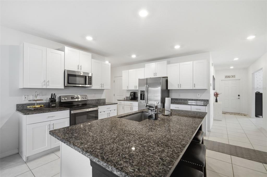 A kitchen with white cabinets, granite countertops, stainless steel appliances, and a central island — 6469 BAR S BAR TRAIL, ZEPHYRHILLS, FL