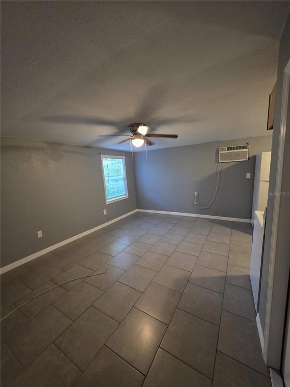 An interior room features gray walls, a ceiling fan, and large gray floor tiles — 1328 37TH STREET NW, WINTER HAVEN, FL