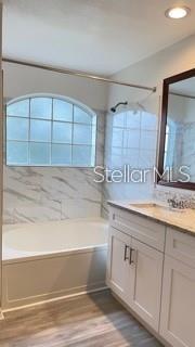 A bathroom features a white vanity, a soaking tub, and a window with a shower curtain — 7270 WESTPOINTE BOULEVARD UNIT 933, ORLANDO, FL