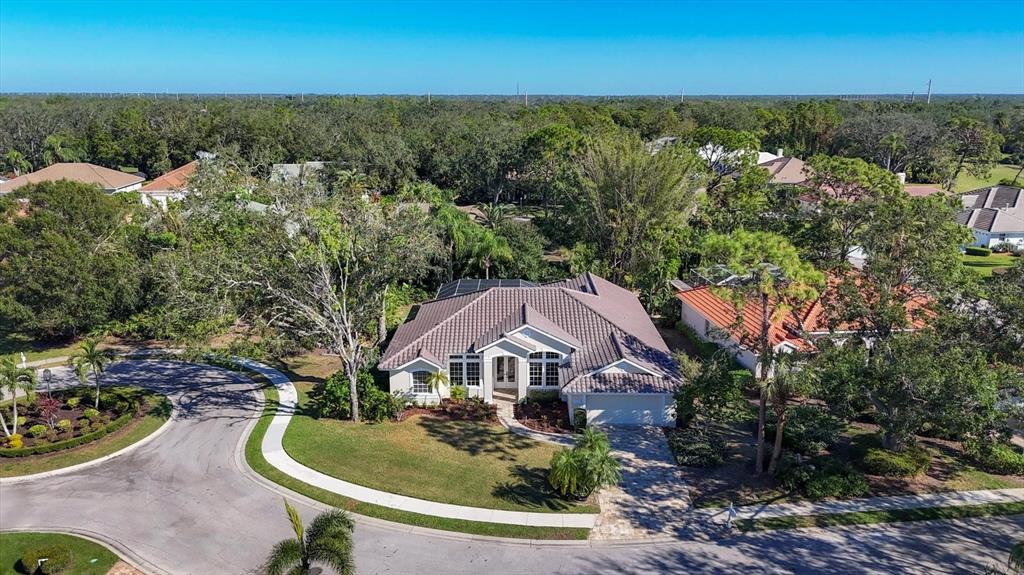 An aerial view of a single-story house with a tiled roof and a paved driveway — 6615 HUNTER COMBE CROSSING, UNIVERSITY PARK, FL