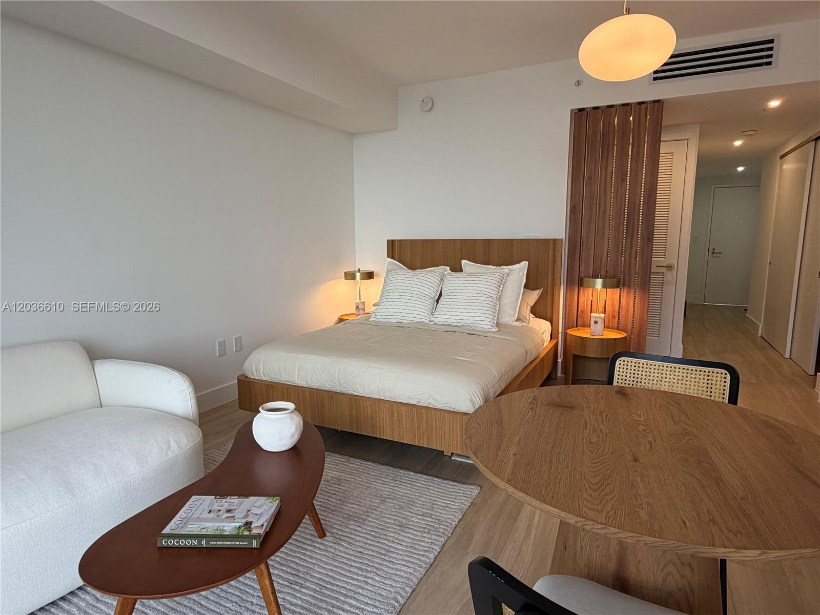 A studio apartment features a bed, a small dining area, and a white sofa — 90 NE 32 # 1014, Miami FL 33149, MIAMI, FL