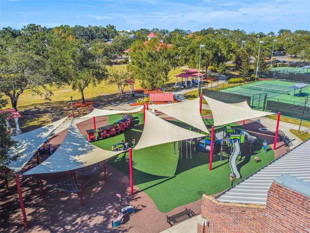 An aerial view of a public park featuring a shaded playground, train structure, and tennis courts — 518 INGLESIDE LANE, HAINES CITY, FL