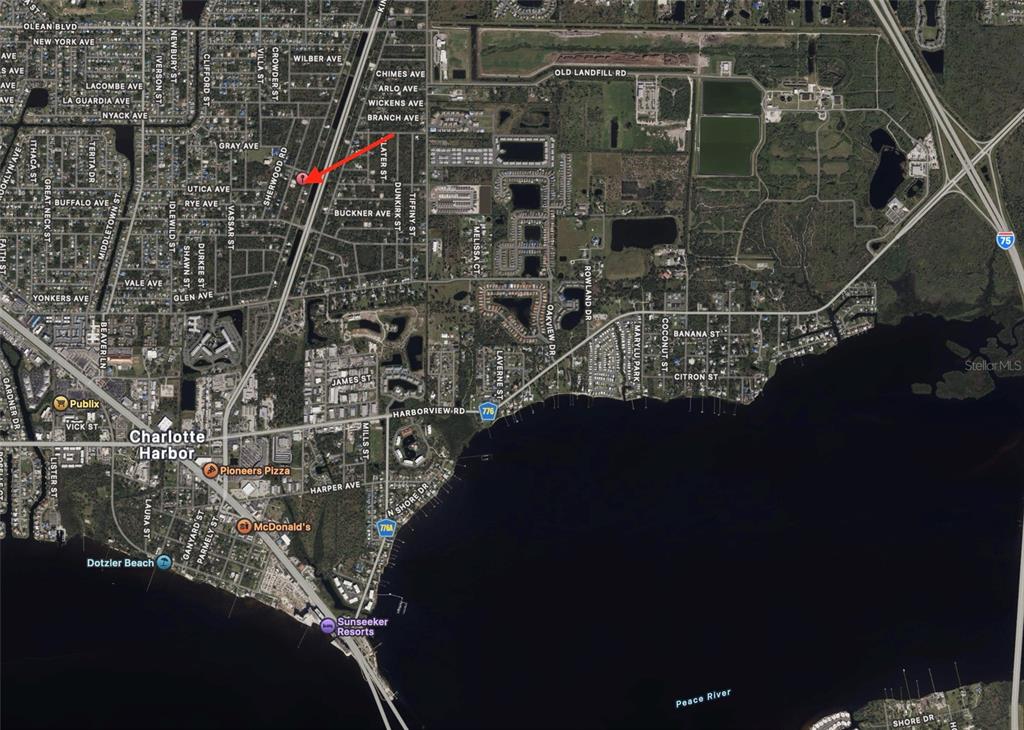 A vacant, grassy residential lot with a for sale sign and surrounding houses — 3419 VESSELS ROAD, PORT CHARLOTTE, FL
