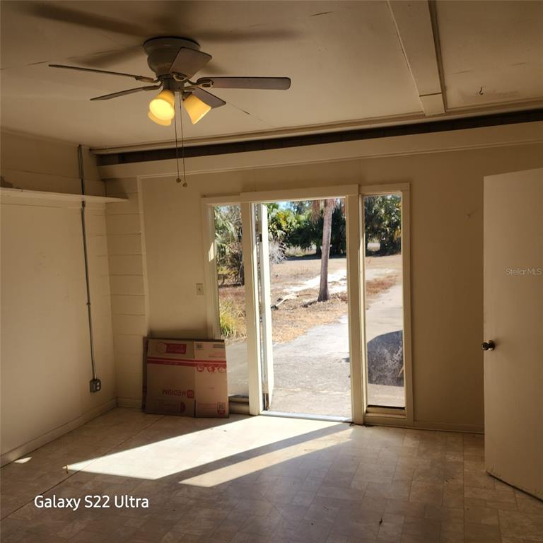 A room with a ceiling fan, tile flooring, and a glass door leading outside — 1870 SW PAX DUCES DRIVE E UNIT 1868, ARCADIA, FL