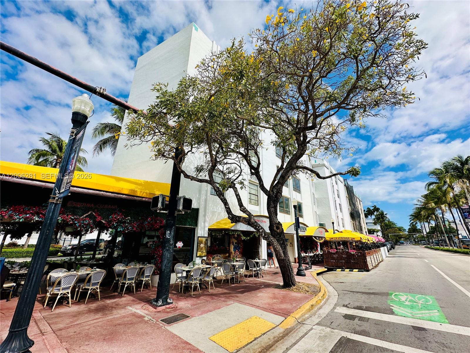 A street-level view shows a white building with outdoor restaurant seating under yellow awnings — 710 Washington Ave # 321, Miami Beach FL 33139, MIAMI BEACH, FL