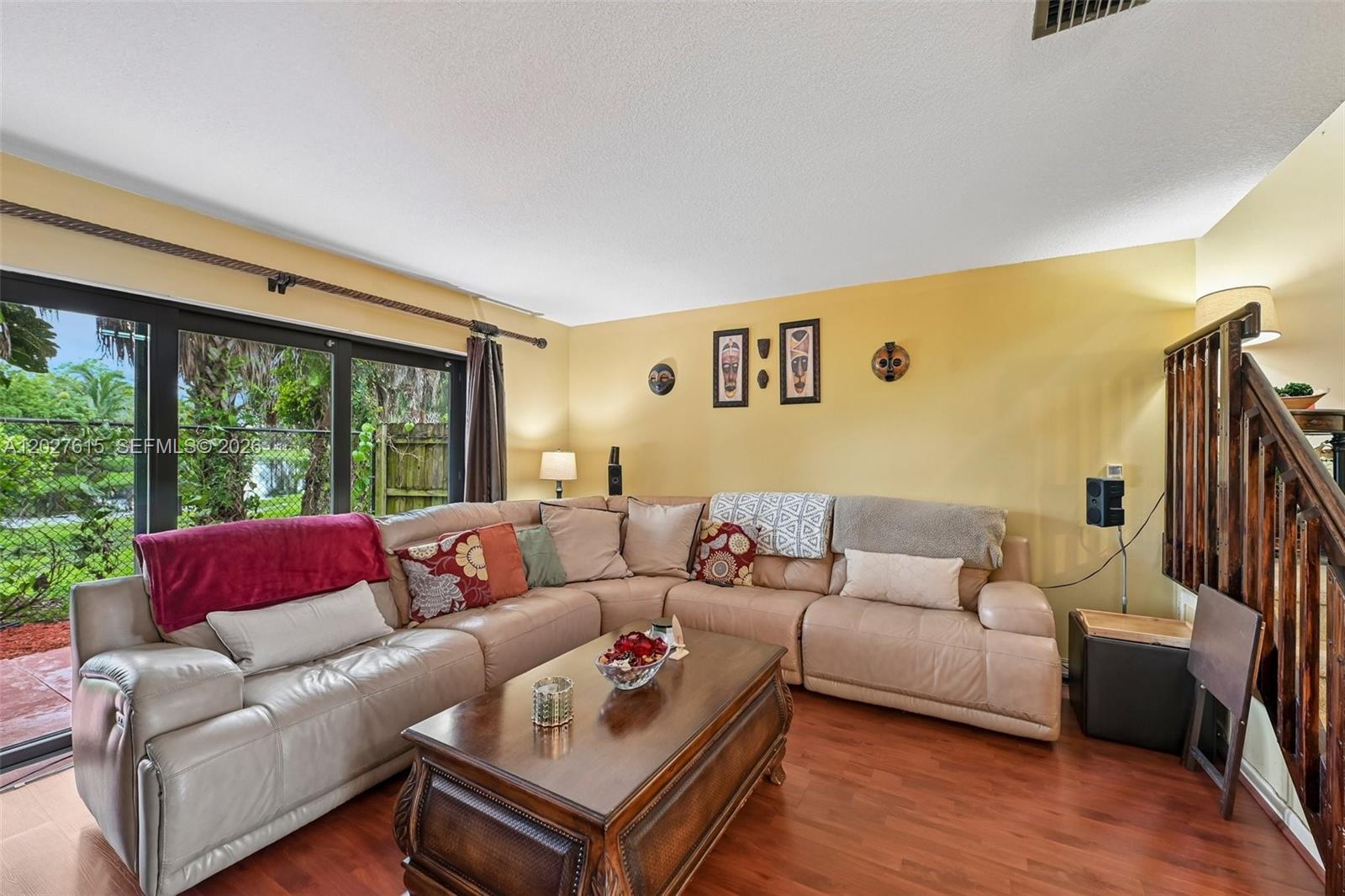 A living room features a large beige sectional sofa, a wooden coffee table, and sliding glass doors — 3461 Cluster Rd, Miramar FL 33025, MIRAMAR, FL