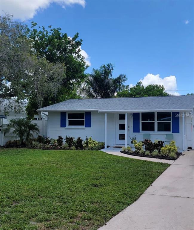 A white single-story house with blue shutters, a gray roof, and a front lawn — 3440 CHAPEL DRIVE, SARASOTA, FL