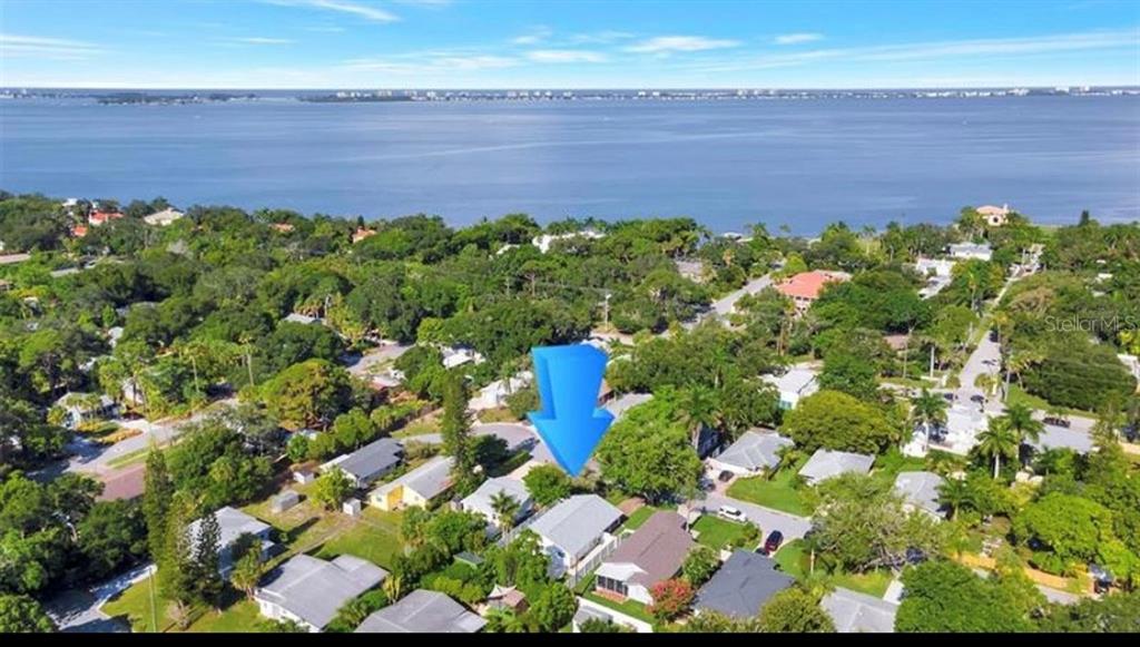 An aerial view shows a residential neighborhood with houses surrounded by trees near a bay — 3440 CHAPEL DRIVE, SARASOTA, FL