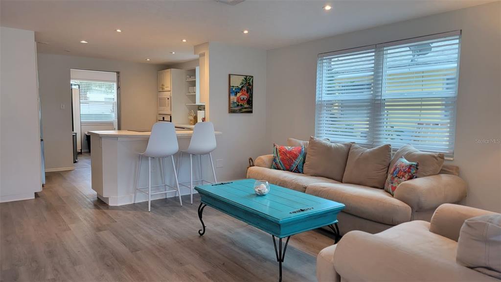 A living room with a turquoise coffee table, a beige sofa, and a kitchen island — 3440 CHAPEL DRIVE, SARASOTA, FL