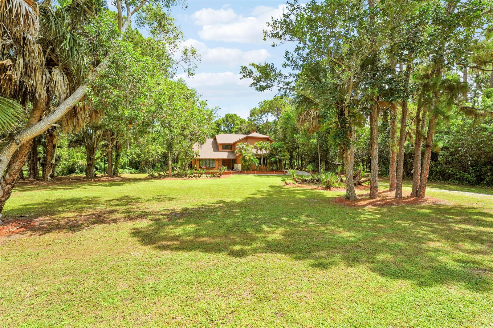 A two-story house with a brown exterior sits at the end of a grassy lawn — 12613 189th Court N, Jupiter FL 33478, JUPITER, FL