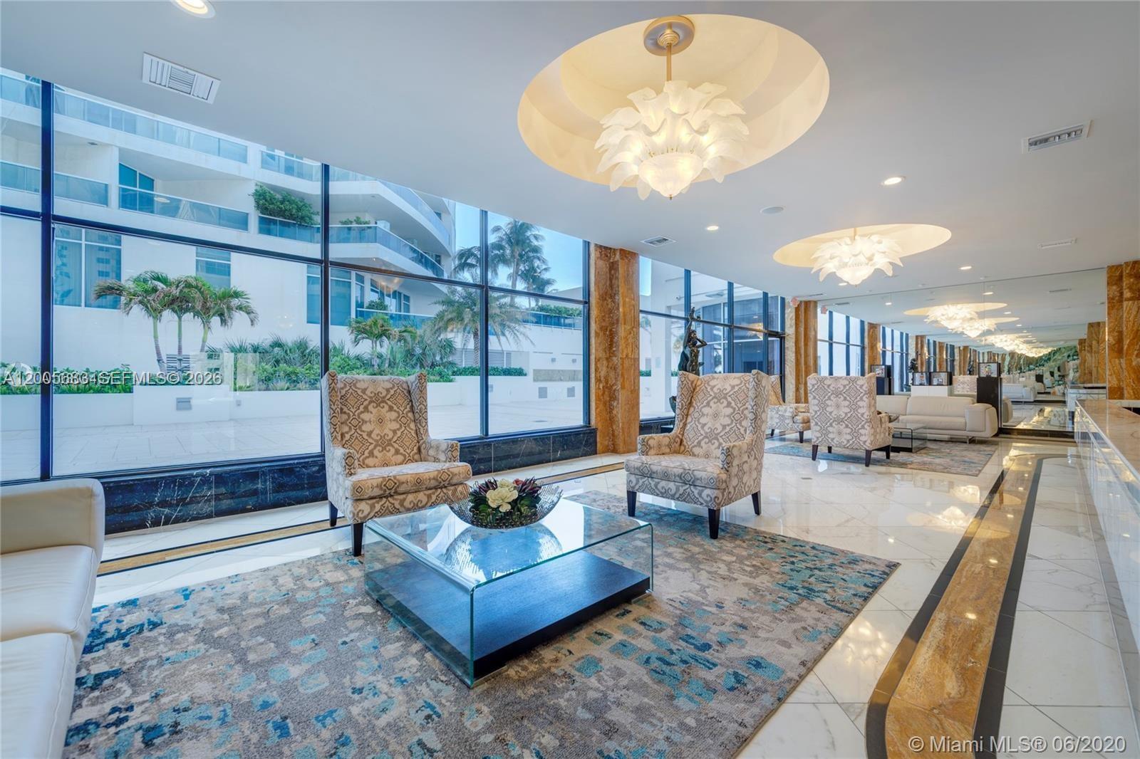 A modern lobby features patterned armchairs, glass coffee tables, marble floors, and floor-to-ceiling windows — 2751 S Ocean Dr # 701N, Hollywood FL 33019, HOLLYWOOD, FL